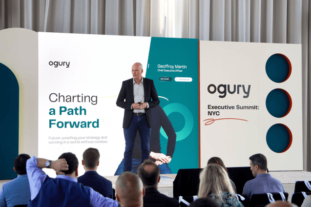 Geoffrey Martin, CEO, Ogury stands in front of presentation on stage